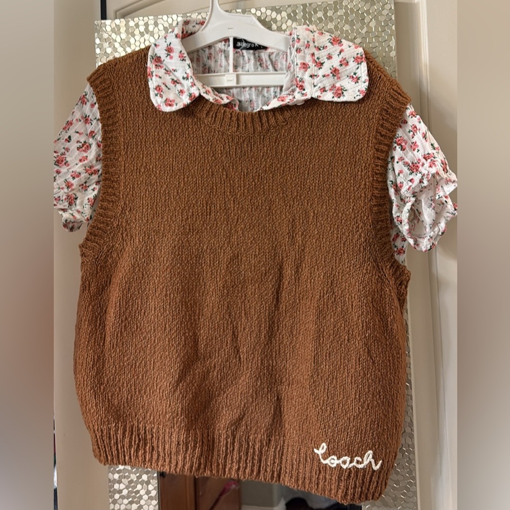 Coach sweater vest with floral button up shirt sleeve shirt.